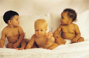 three babies playing on bed