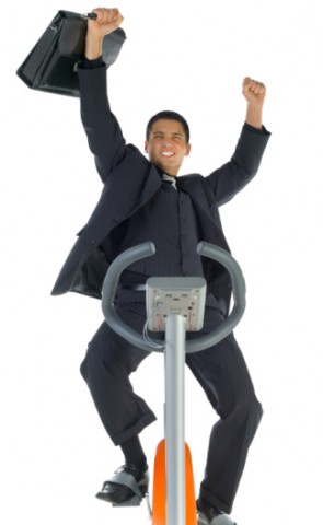 man in business suit on eliptical machine