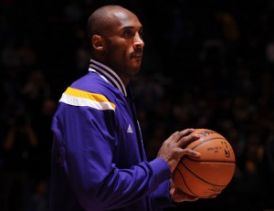 Photo of Kobe Bryant in a Lakers jacket holding a basketball