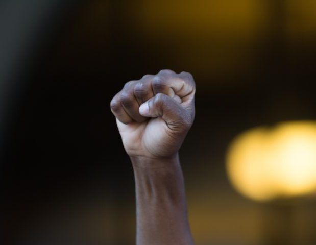 Los Angeles, USA - July 12, 2016 - Black lives matter protestor put their fists in the air as a sign of 'black power' on City Hall following ruling on LAPD fatal shooting of African American female Redel Jones