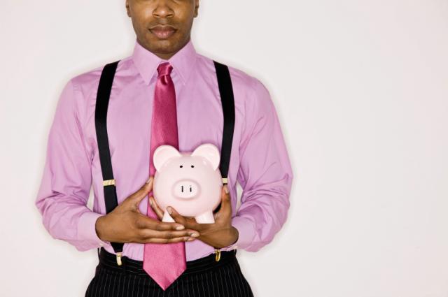 Confident businessman holding piggy bank