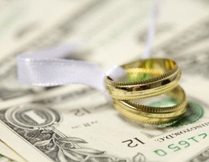 wedding rings sitting atop dollar bills