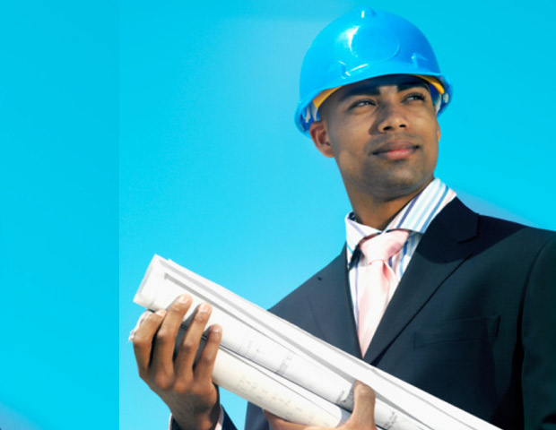 african american engineer in blue hard hat and holding blueprints