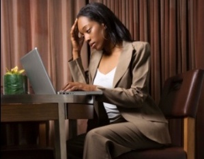 Black woman exhausted and stressed at desk