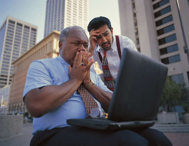 Shocked businessmen looking at computer