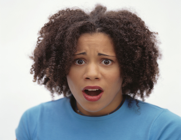 Young woman with horrified expression, posing in studio, portrait