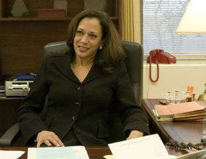 kamala harris smiling at desk