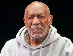 Bill Cosby wearing a grey sweatshirt and a lavalier mic