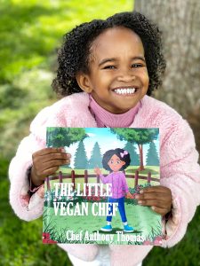 Ashlyn holding the Little Vegan Cookbook