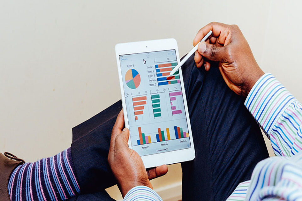 man using ipad with graphs