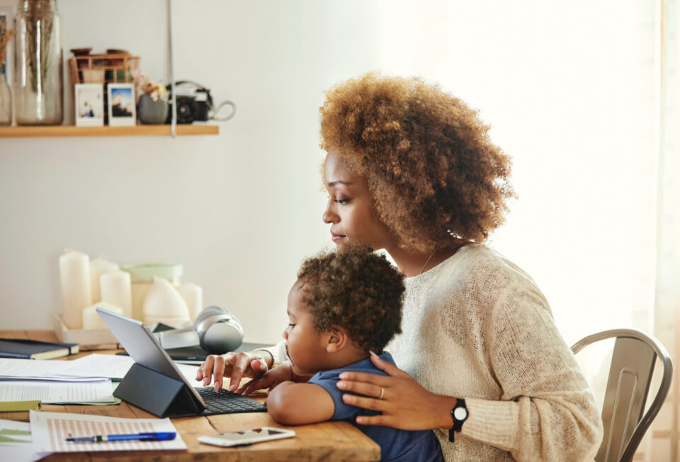 Mother with son working on digital tablet at home