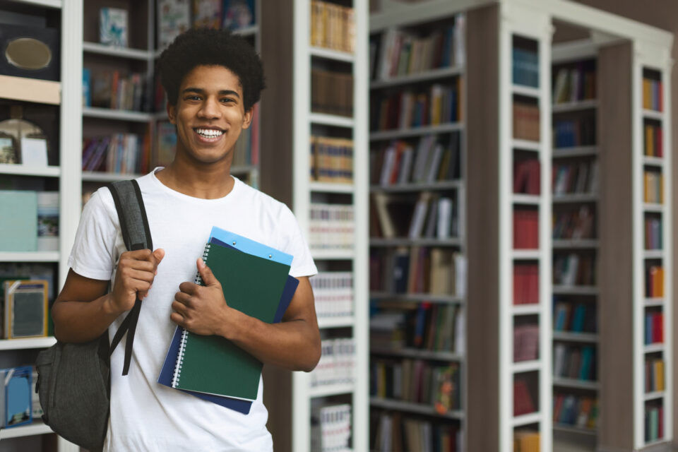 Student posing on bookshelves, scholarship, school,