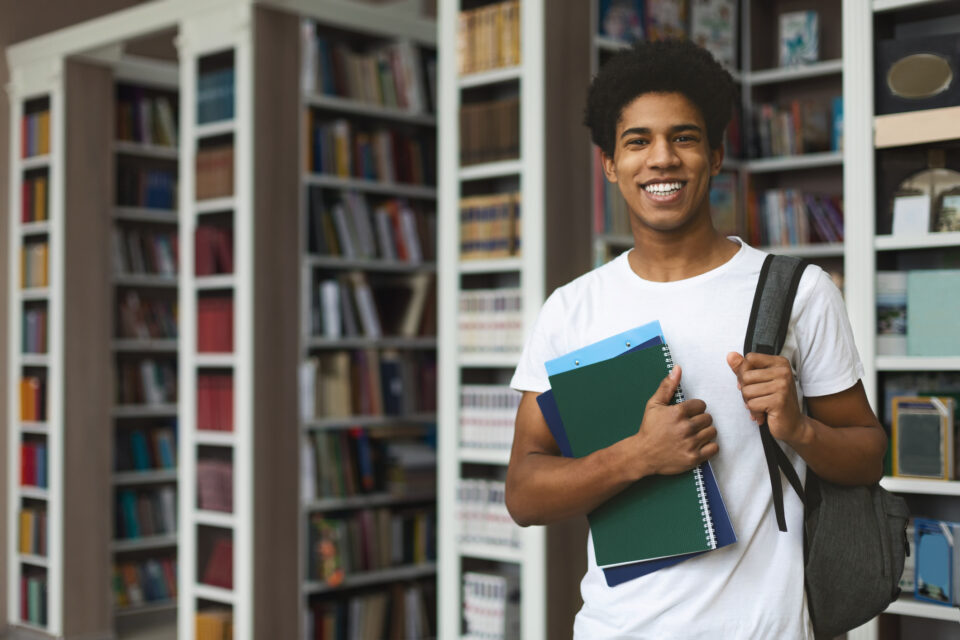 Student posing on bookshelves background