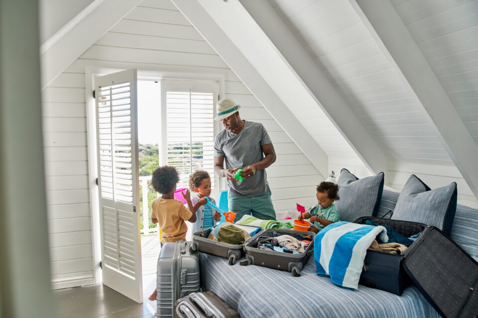 Dad and children packing suitcases on vacation