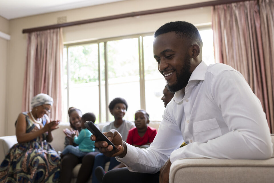 Smiling father reading good news on an app on his phone