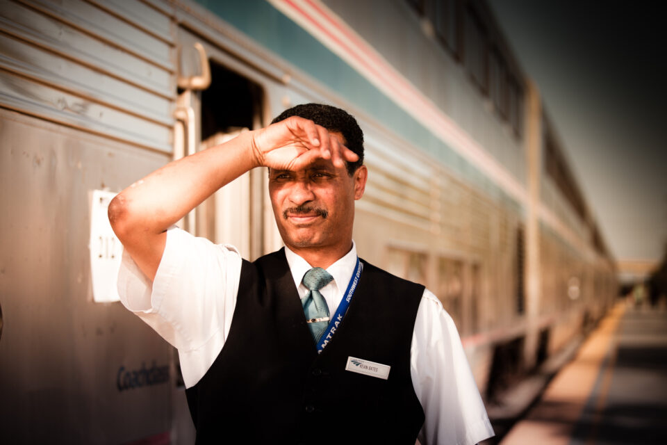 Amtrak train crew member sheilds his eyes from the bright desert sun as the Amtrak Sunset Limited from Los Angeles to New Orleans boards at the Palm Springs Amtrak Station