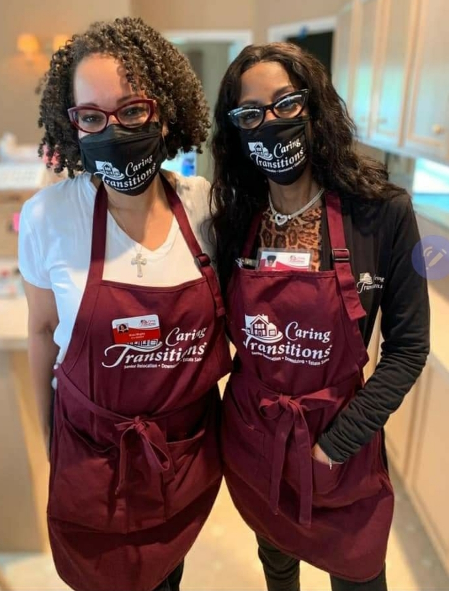 Bigby and Dunn-Henry pose in Caring Transitions aprons