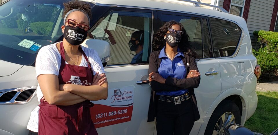 Bigby and Dunn-Henry stand in front of Caring Transitions truck